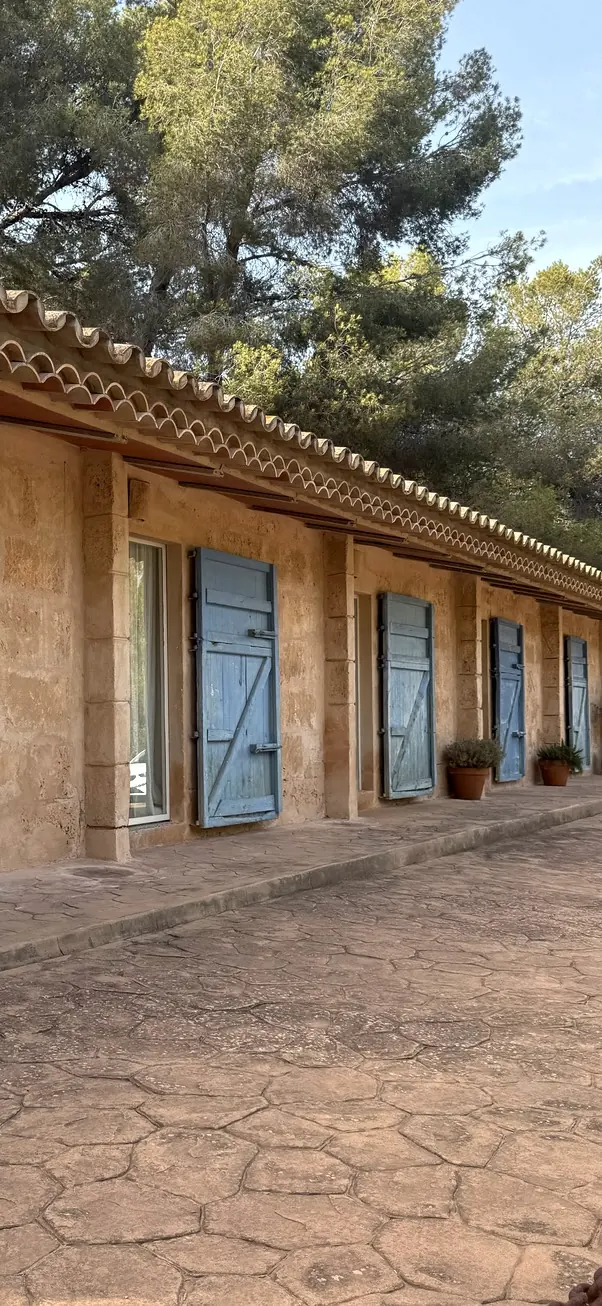 Restaurierte Finca mit hellblauen Fensterläden und Sandsteinmauern auf Mallorca