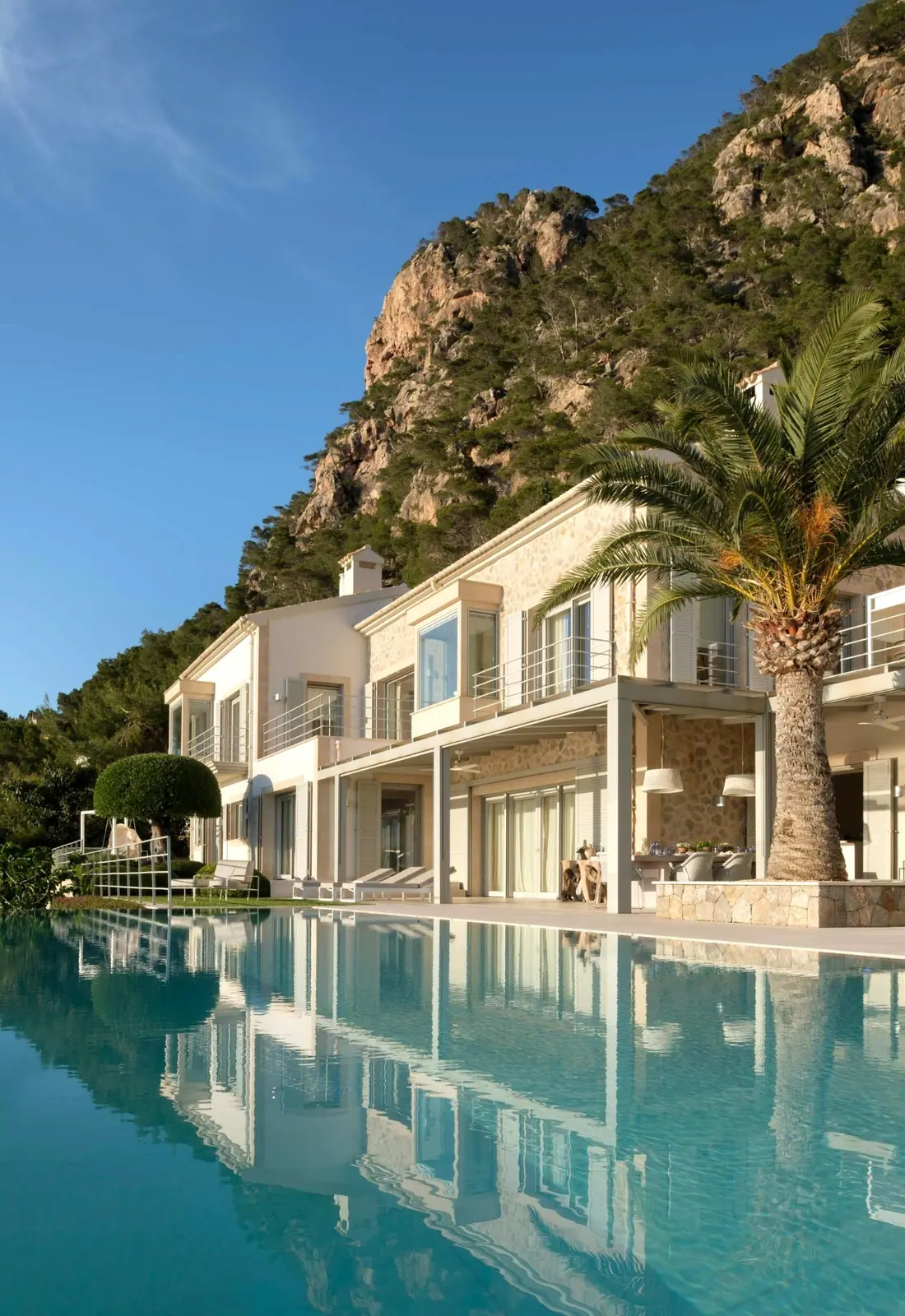 Moderne Villa mit Pool, Palme und Tramuntana-Felsen im Hintergrund