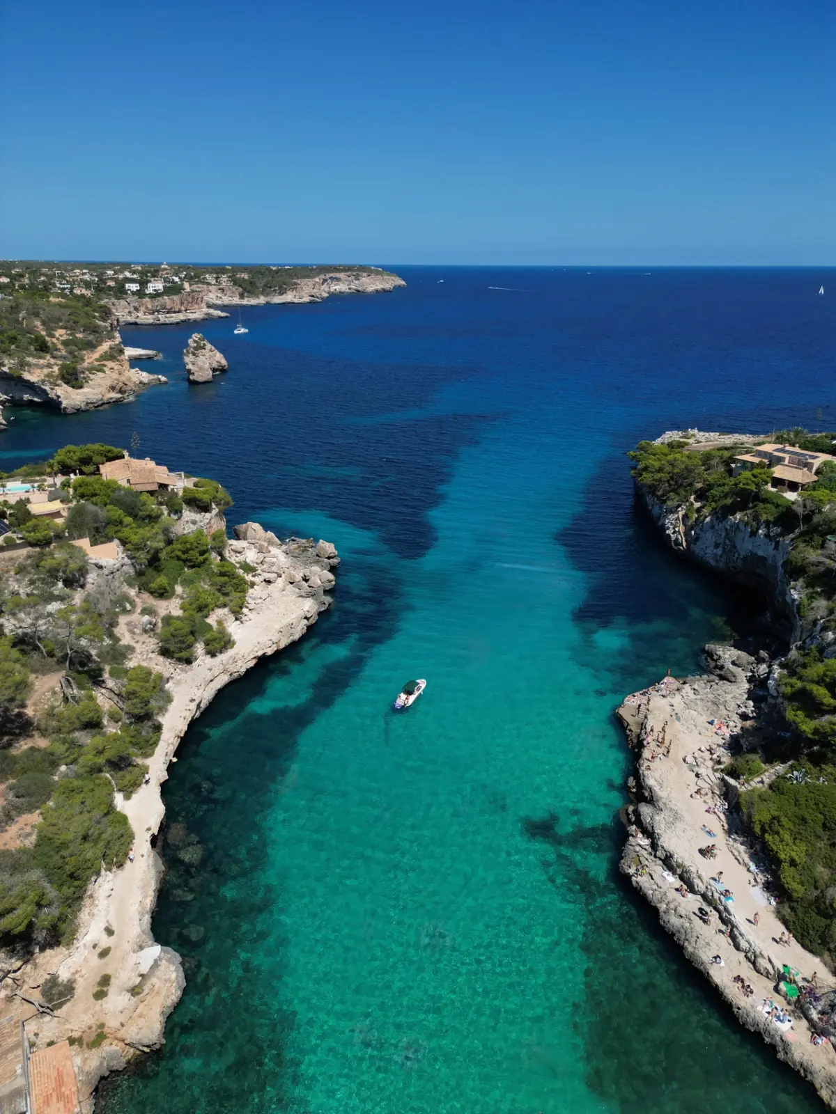 Türkisfarbene Felsbucht auf Mallorca aus der Vogelperspektive mit Booten und Badegästen